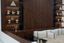 تصميم داخلي لصالة فيلا مودرن فاخرة بحي حطين بالرياض تتميز بجدار من بديل الرخام الأبيض ذي العروق الرمادية مدمج مع إضاءة ليد دافئة وأسقف جبس بورد فلات ناعمة