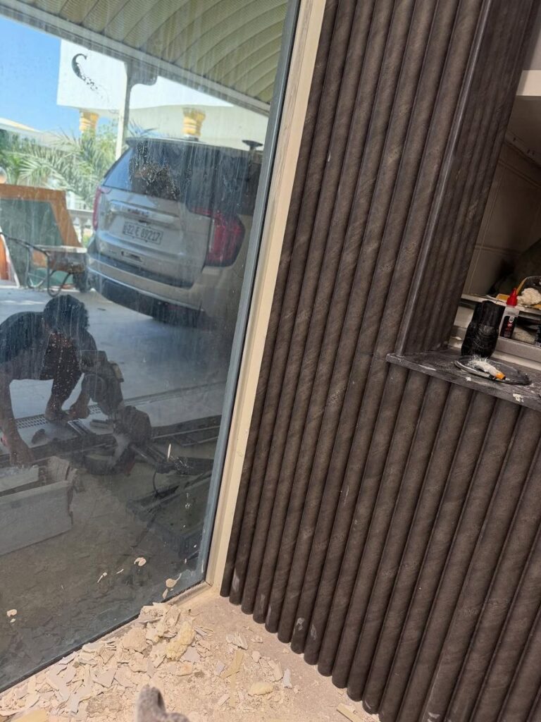 تركيب تكسيات بديل الخشب للجدران بلون بني عسلي مدمجة مع إضاءة ليد مخفية وبديل الرخام الأبيض في صالة فيلا مودرن بحي الياسمين بالرياض